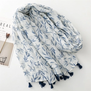 Elegant cotton linen scarf with blue leaf print and tassels on a white background