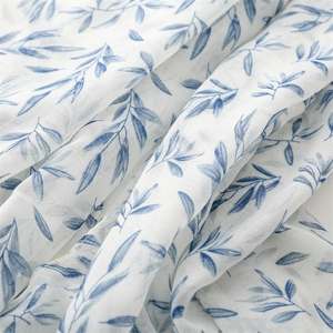 Detail of cotton linen scarf showing blue leaf pattern and breathable fabric texture