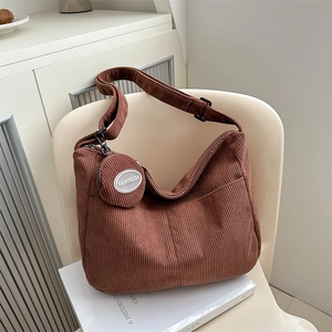 Brown corduroy tote bag with small round pouch on a chair, minimalist autumn style