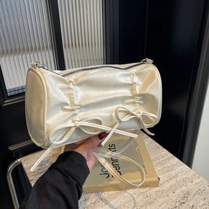 Chic beige pleated cylinder crossbody bag with cute double bows and silver zipper detail