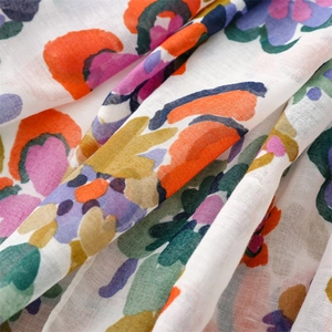 Close-up of cotton linen scarf showing colorful watercolor flower patterns and texture