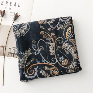 Detail of dark blue paisley scarf with soft tassels and intricate floral patterns