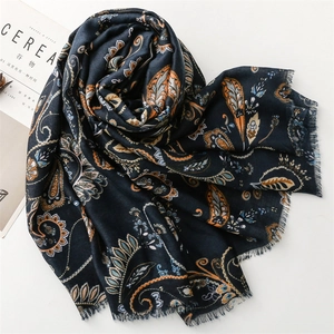Detail of dark blue paisley scarf with soft frayed edges and elegant floral patterns