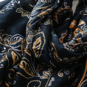 Detailed view of paisley print scarf with soft cotton-linen texture and frayed edges