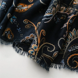 Detailed view of paisley patterns on navy cotton-linen scarf with fringed edges