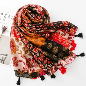 Detail of bohemian scarf with ethnic paisley print and vibrant tassel fringe detail