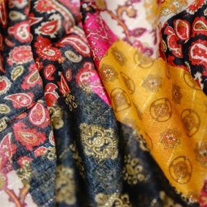 Close-up of bohemian paisley printed scarf with red floral patterns and silver lurex threads