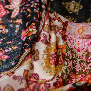 Macro detail of ethnic paisley print shawl with woven metallic silver thread textures
