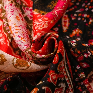 Macro shot of ethnic boho scarf fabric with red floral patterns and silver silk threads