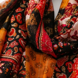 Macro shot of paisley print scarf with shimmering gold metallic thread detail