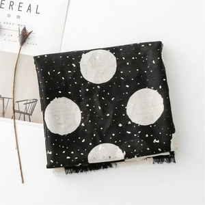 Detail of black cotton linen scarf with white polka dots, gold foil stars and fringe trim