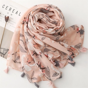Dettaglio di scialle rosa a fiori effetto lino con eleganti nappe decorative