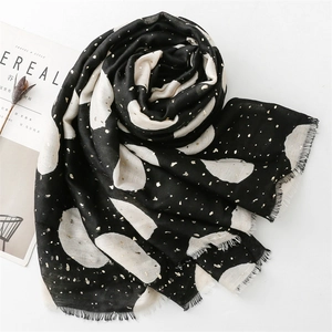 Detail of black and white cotton-linen scarf with gold foil dots and raw fringe edges