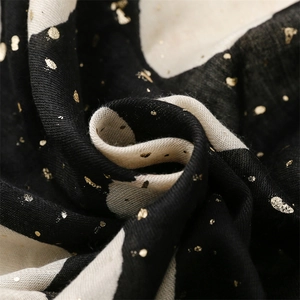 Detailed close-up of woven fabric scarf with gold foil dots and cotton linen texture