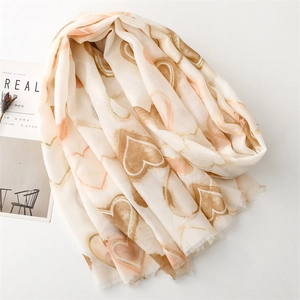 Close-up of heart print scarf with gold foil accents and natural fringed edges