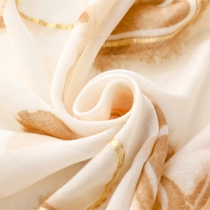 Macro shot of cotton linen scarf with elegant gold foil heart patterns and brown brushstrokes