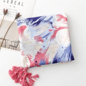 Detail of abstract print shawl with pink fringe tassels on a minimalist background