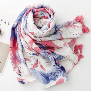 Close-up of pink and blue feather print scarf with gold foil details and tassels