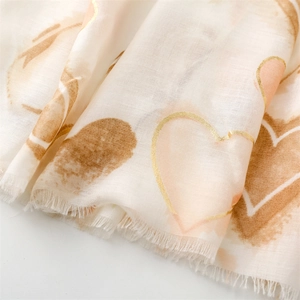 Close-up of heart print scarf with gold foil edges and delicate fringe textures