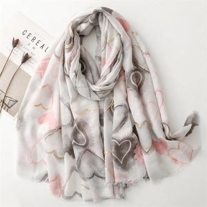 Elegant white cotton-linen feel scarf with gold-trimmed heart patterns and fringe edges