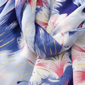 Close-up of cotton linen scarf with blue pink floral patterns and gold foil stripes