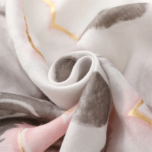Detail of soft cotton-linen scarf with golden heart foil print and pastel patterns