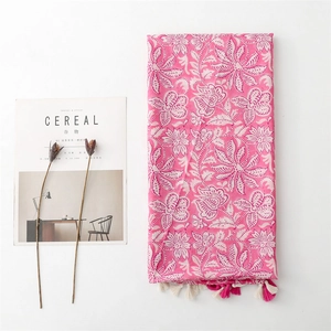 Detailed shot of rose pink linen scarf with white floral prints and fringed tassels