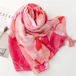 Detail of floral printed pink scarf with soft tassels and lightweight texture