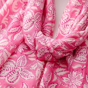 Macro detail of soft pink floral scarf with delicate flower patterns and fabric texture