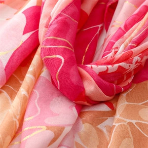 Detailed macro shot of soft floral print fabric with gold outlines and fringe edge