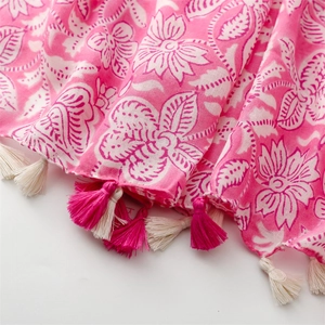 Detailed macro view of pink floral scarf fabric texture and delicate fringe tassels