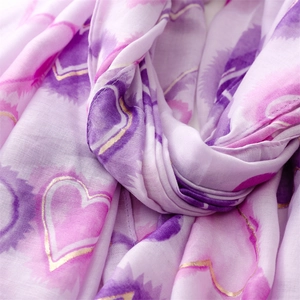 Detailed macro shot of violet and pink ombre heart print scarf with gold foil edges
