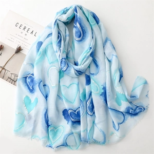Detail of blue heart pattern with silver foil accents and frayed edges on linen scarf