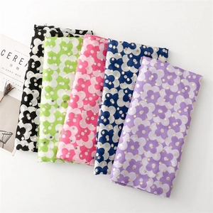 Detailed macro view of four-petal floral scarves with gold foil dots on cotton-linen fabric