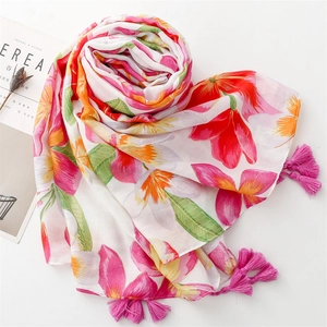 Detail of soft cotton scarf featuring pink tropical floral prints and tassel edges