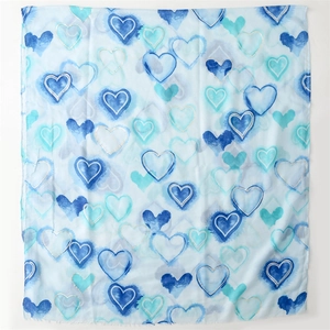 Close-up of light blue scarf with watercolor heart patterns and smooth edges
