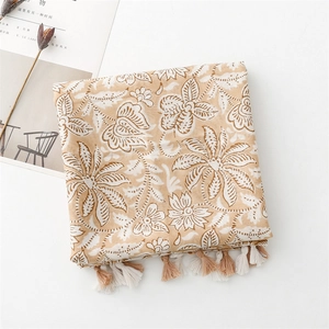 Detail of floral linen-feel scarf with elegant white flower prints and tassel fringe