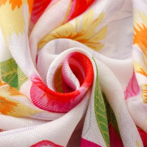 Close-up detail of soft floral scarf with vibrant gold stamping and fine linen texture