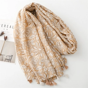 Detail view of khaki cotton-linen scarf with white floral patterns and elegant fringe