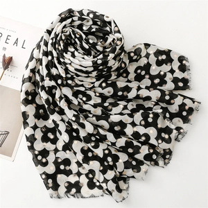 Close-up of black and white floral scarf with gold foil dots and fringe edges