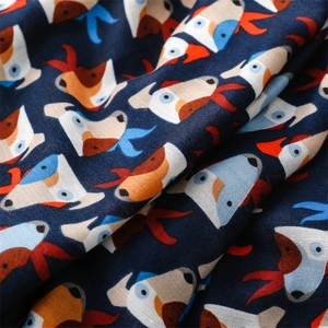 Detailed close-up showing the soft cotton texture and cartoon dog print of the blue scarf