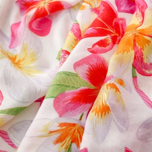 Close-up of herringbone weave fabric with pink floral prints and delicate fringe details