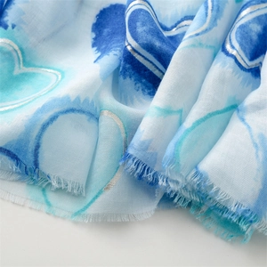 Detail of blue gradient cotton-linen scarf with silver heart print and fringe edge