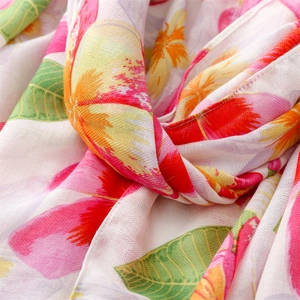 Detailed macro view showing the soft texture and floral print of the pink cotton scarf