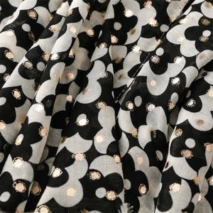 Detail of black and white floral scarf with gold foil dots and soft linen texture