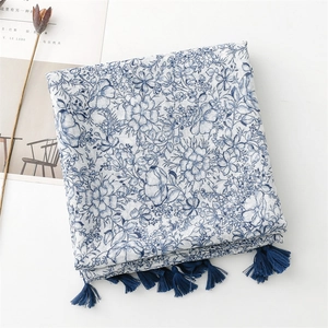 Macro shot of blue floral print scarf with soft texture and deep blue fringe tassels