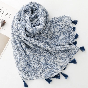 Detail of blue floral print scarf with long tassels and lightweight linen texture