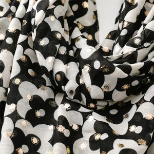 Detailed close-up of floral pattern and gold foil dot texture on soft cotton linen scarf