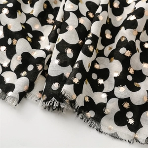 Detail of floral scarf with gold foil dots and delicate fringe trim in soft fabric