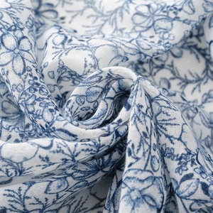 Close-up of blue floral cotton linen fabric showing natural weave texture and folds